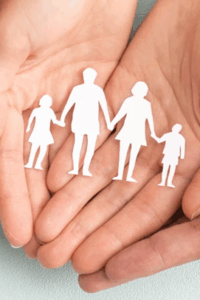 Someon's hands holding a paper cutout of a family